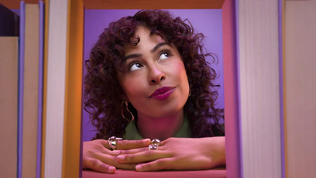 Dark-haired woman's face framed between two standing sets of books
