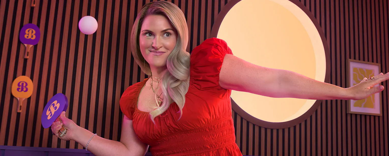 Woman in a red shirt holding a ping pong paddle about to hit a ping pong ball Woman in a red shirt holding a ping pong paddle about to hit a ping pong ball
