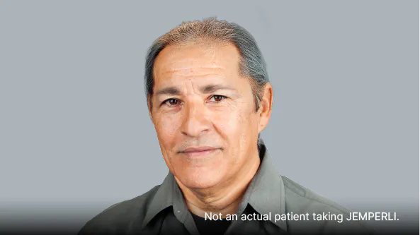 Man with gray hair wearing a gray collared shirt
