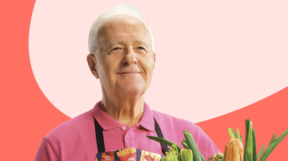 An older white male wearing a pink shirt and holding a bouquet of flowers. An older white male wearing a pink shirt and holding a bouquet of flowers.