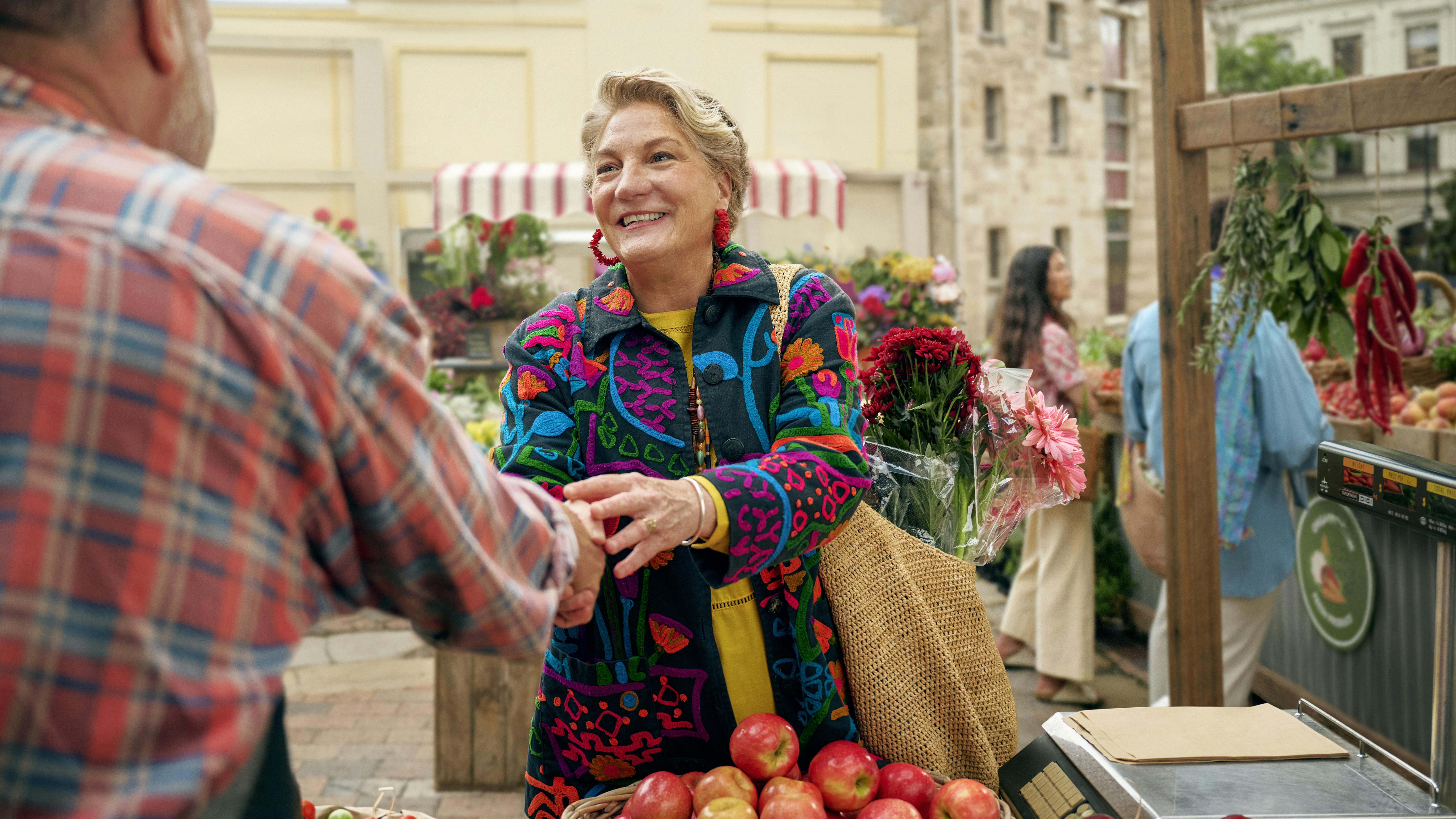 Woman shaking hands with man at outdoor farmers market