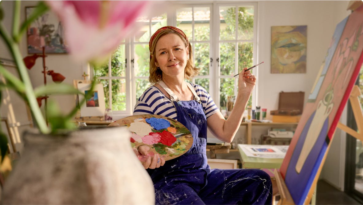EGPA patient Meredith painting in her studio