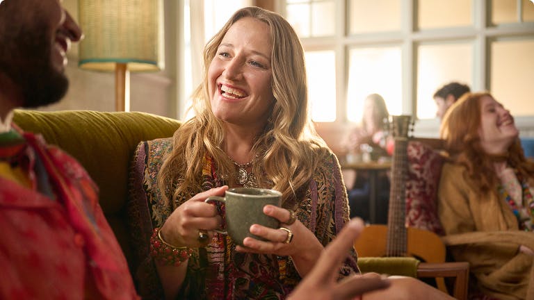 Nasal polyps patient Janet drinking coffee while talking to man on couch