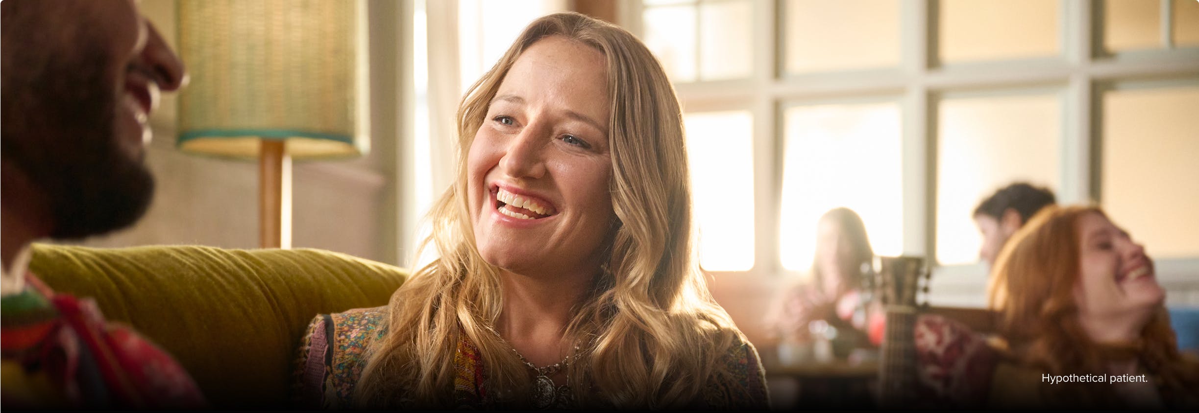 Nasal polyps patient Janet smiling at a friend on a couch in a coffee shop