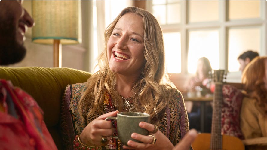 Nasal polyps patient Janet drinking coffee while talking to man on couch