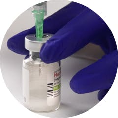 Gloved hand holding syringe in NUCALA lyophilized powder vial