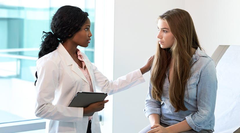 Teen talking to her doctor in an exam room