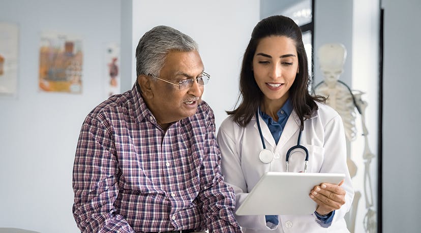 Doctor reviewing a file on her clipboard with a patient