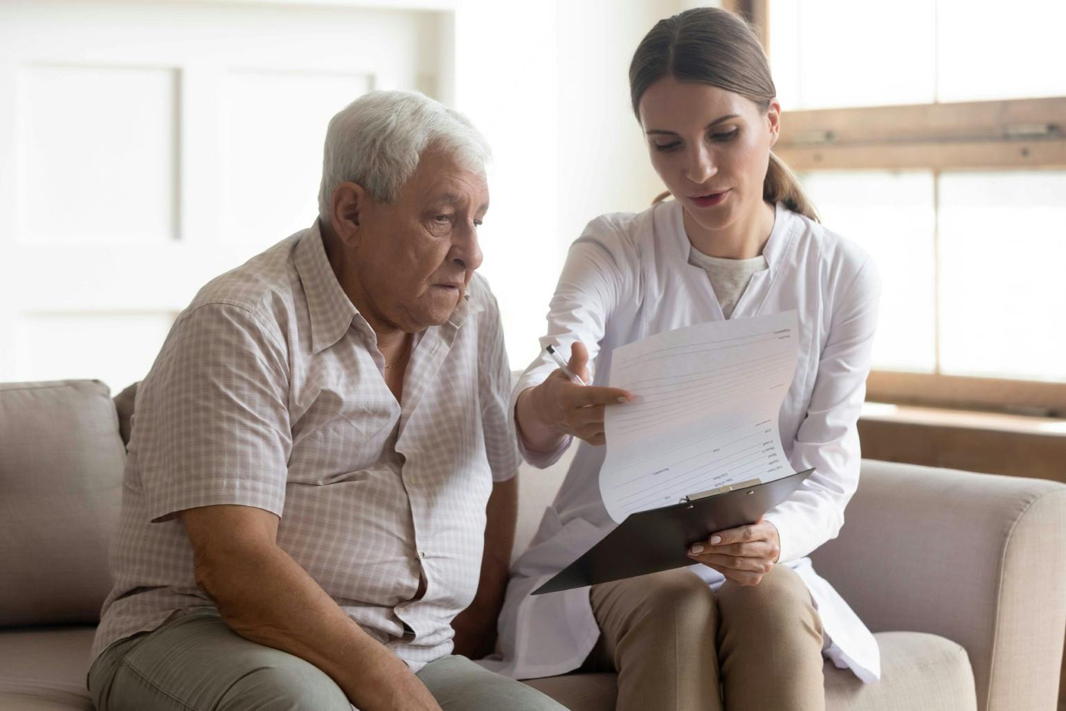 Female medical worker giving consultation to elderly patient