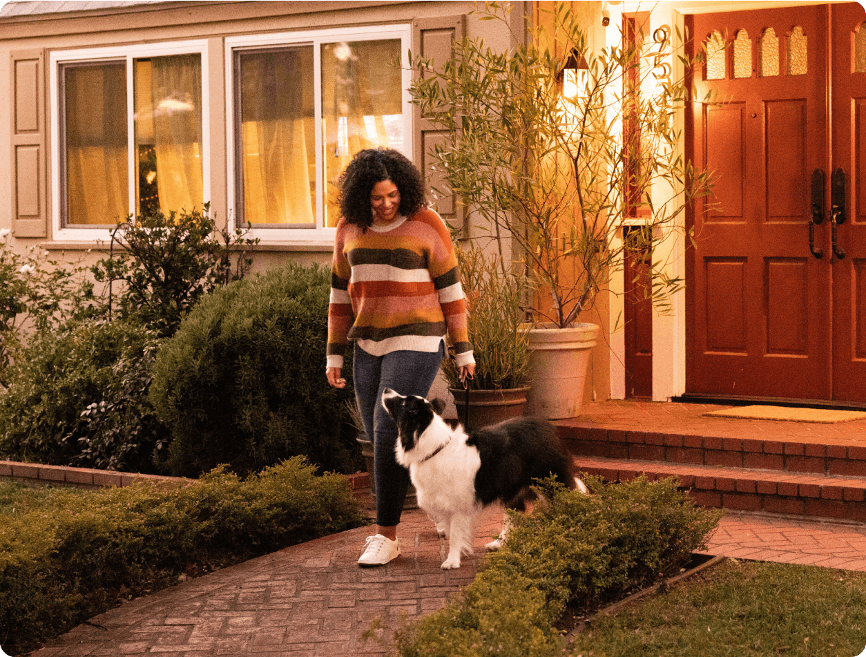 Woman smiling at a Border Collie as they leave the house on a walk