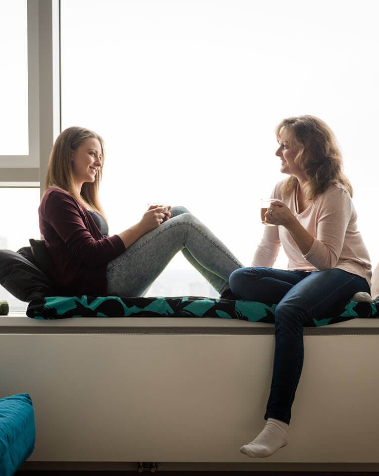 Mom and teen next to window