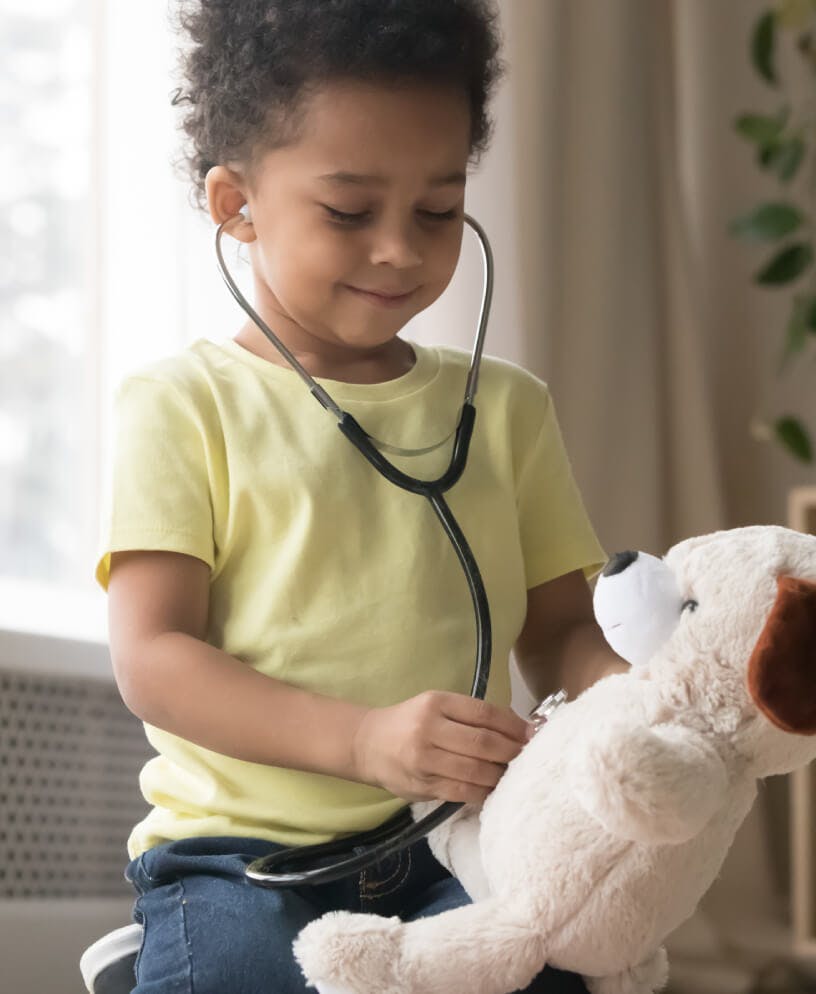 Young black boy playing with doctor