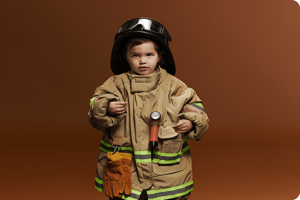 Criança vestida com roupa de bombeiro