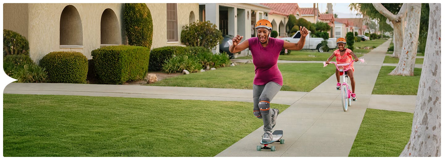 Adult immunization hero of woman skateboarding and daughter riding bike Adult immunization hero of woman skateboarding and daughter riding bike