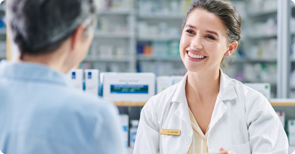 Image: Pharmacist smiling at patient Image: Pharmacist smiling at patient
