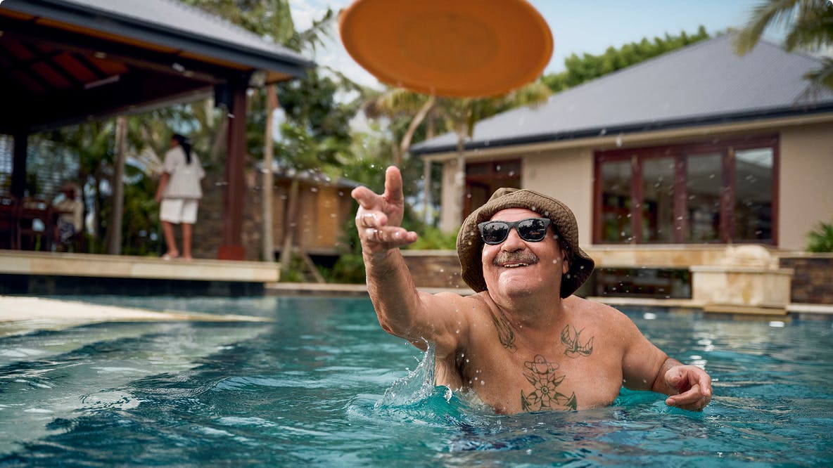 COPD patient Nicholas throwing a Frisbee in an outdoor pool