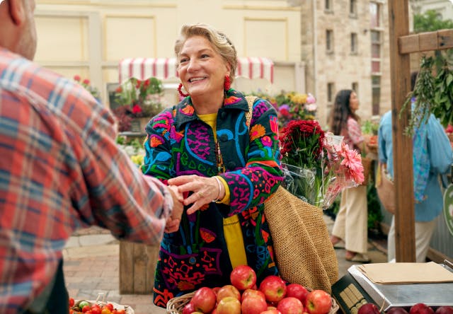 Woman shaking hands with man at outdoor farmers market