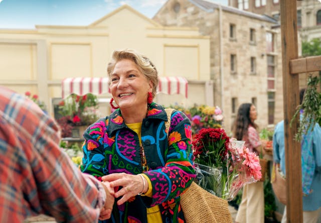 Woman shaking hands with man at outdoor farmers market