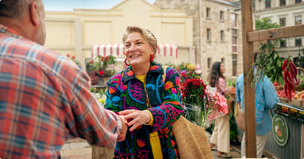 Woman shaking hands with man at outdoor farmers market