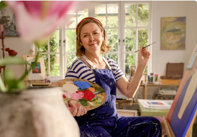EGPA patient Meredith painting in her studio