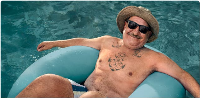 COPD patient Nicholas floating in a pool with a hat and sunglasses