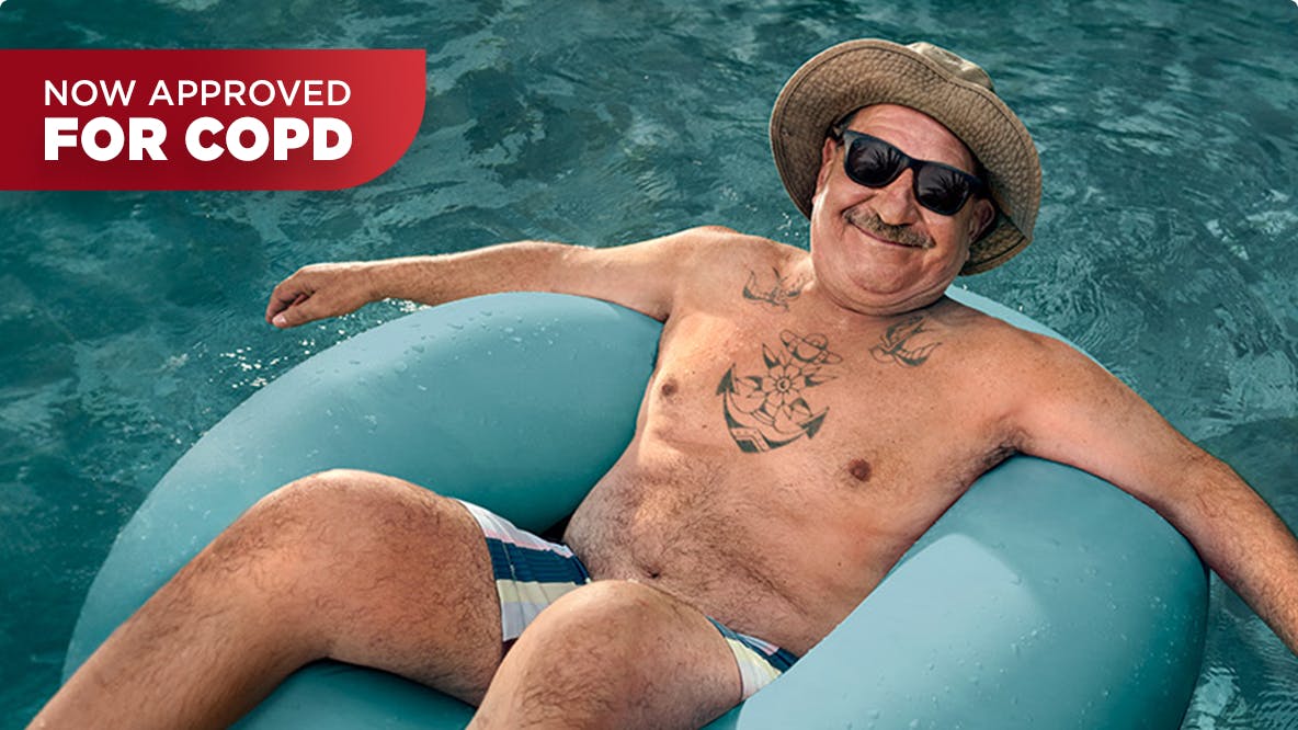 COPD patient Nicholas floating in a pool with a hat and sunglasses