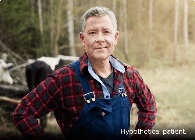 Nasal polyps patient Frank standing in a wooded area with cows