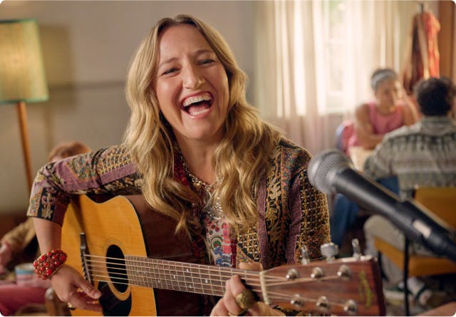 Nasal polyps patient Janet playing guitar in a coffee shop