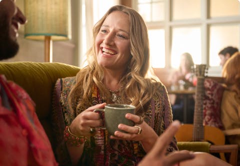 Nasal polyps patient Janet drinking coffee while talking to man on couch