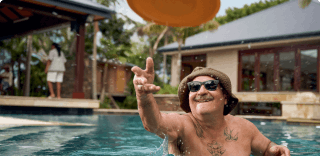COPD patient Nicholas throwing a Frisbee in an outdoor pool