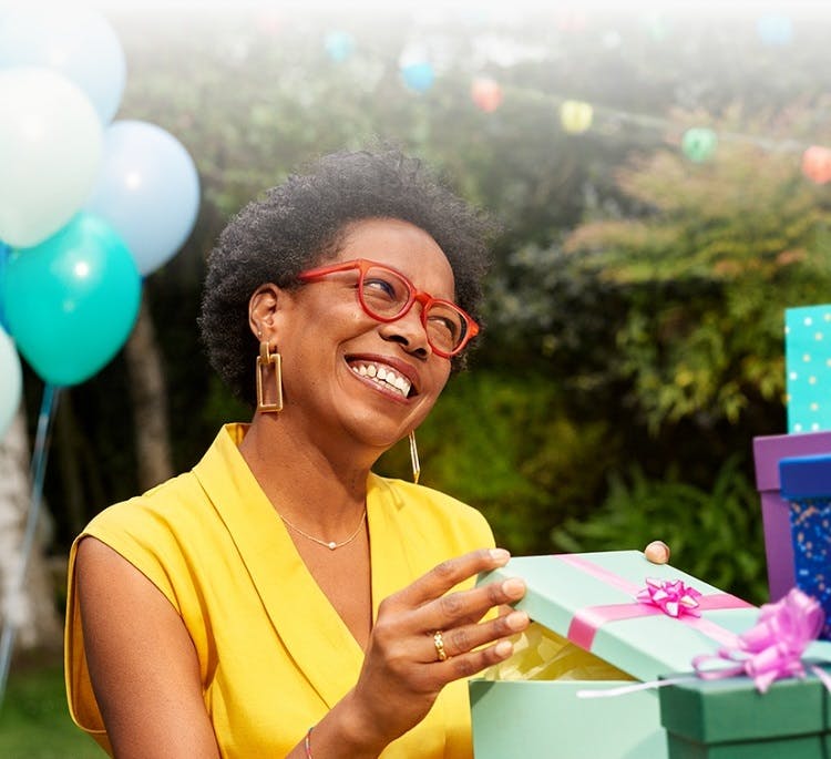 Image: Woman smiling while opening gift