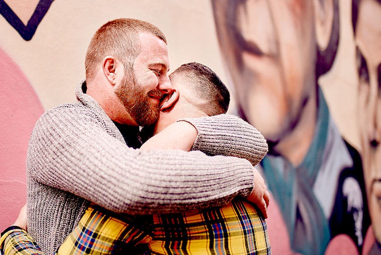 Two men with HIV embracing each other