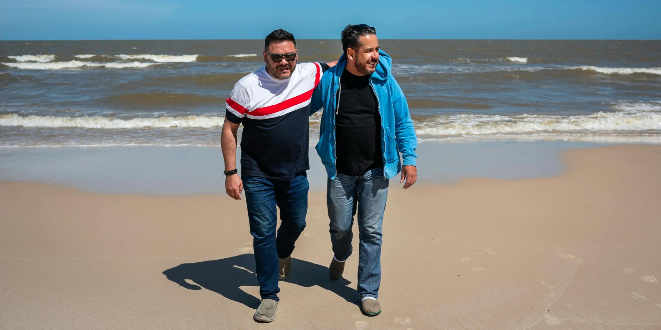 Two men walking together on a beach