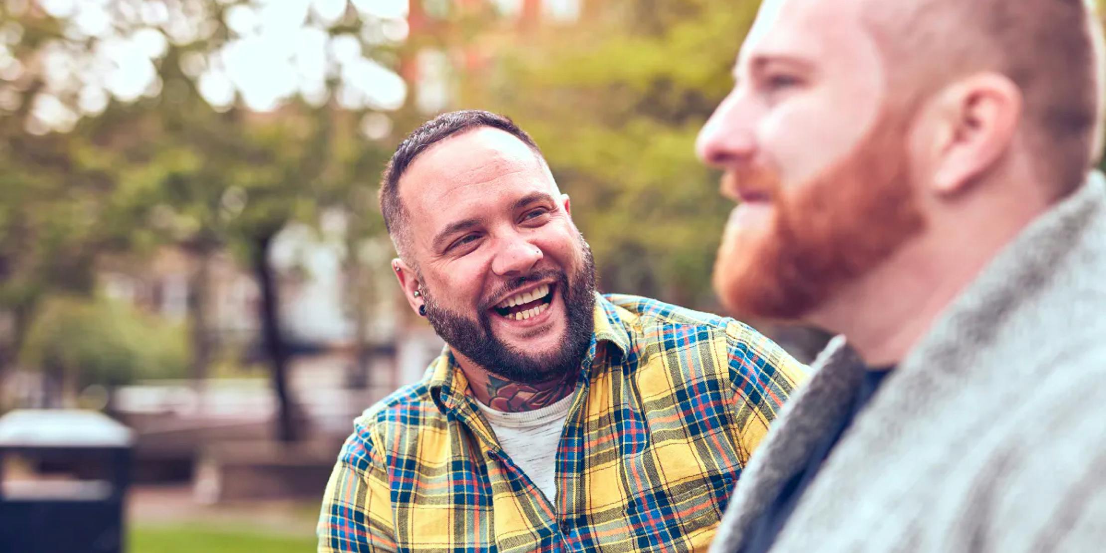 Two men outside on street smilling