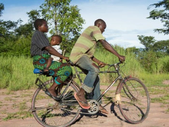 man and woman riding bike with child