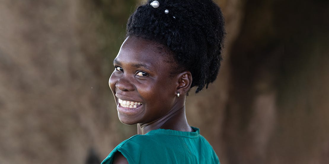A person smiling with a blue shirt
