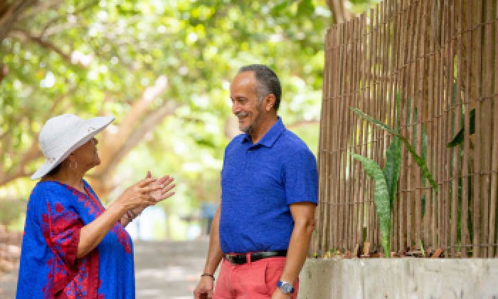 Smiling senior man talking to a woman in the park