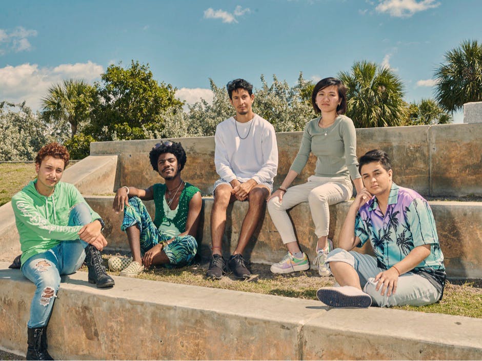 Group of five people sitting on stone bleachers