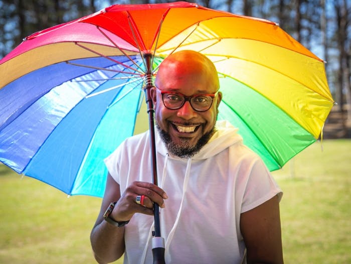 Close-up of man with rainbow umbrella. Close-up of man with rainbow umbrella.