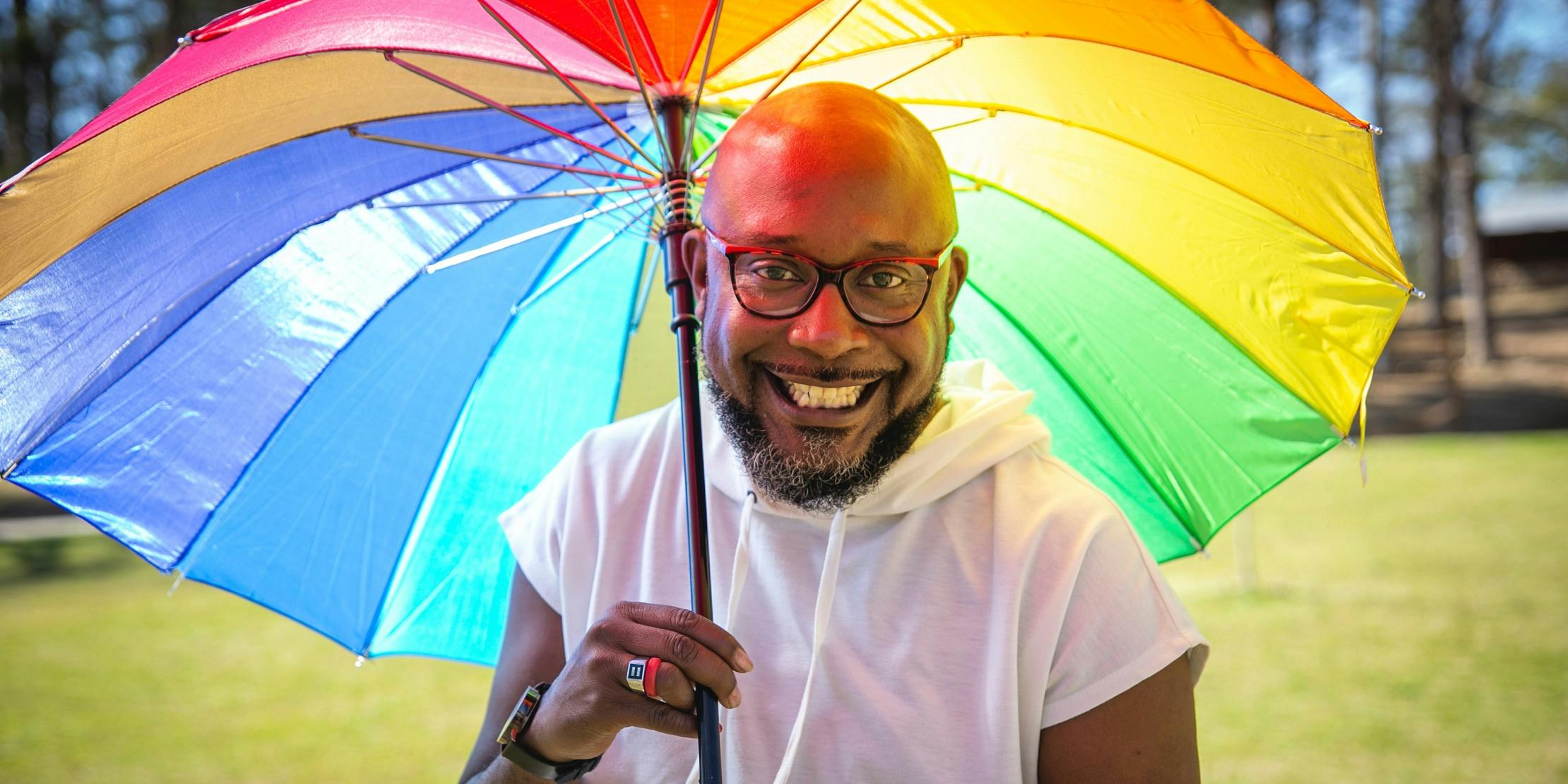 Close-up of man with rainbow umbrella. Close-up of man with rainbow umbrella.