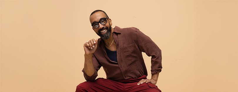 Happy man with glasses sitting on a stool