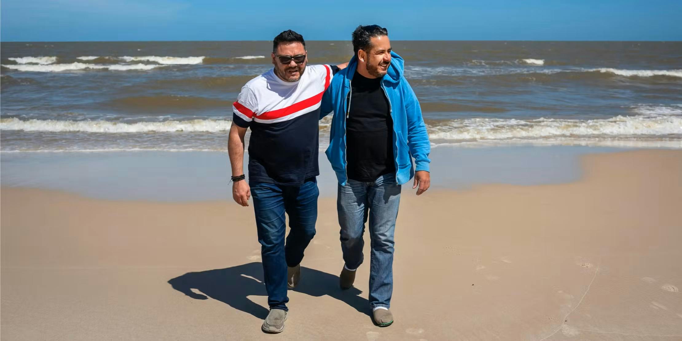 Two men walking together on a beach
