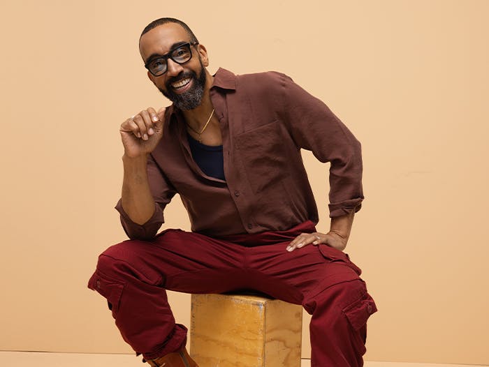 Happy man with glasses sitting on a stool