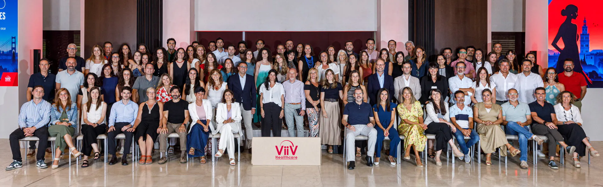 Dos hombres sentados en un banco hablando y sonriendo