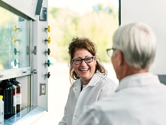 Dos científicos hablando y riendo en un laboratorio